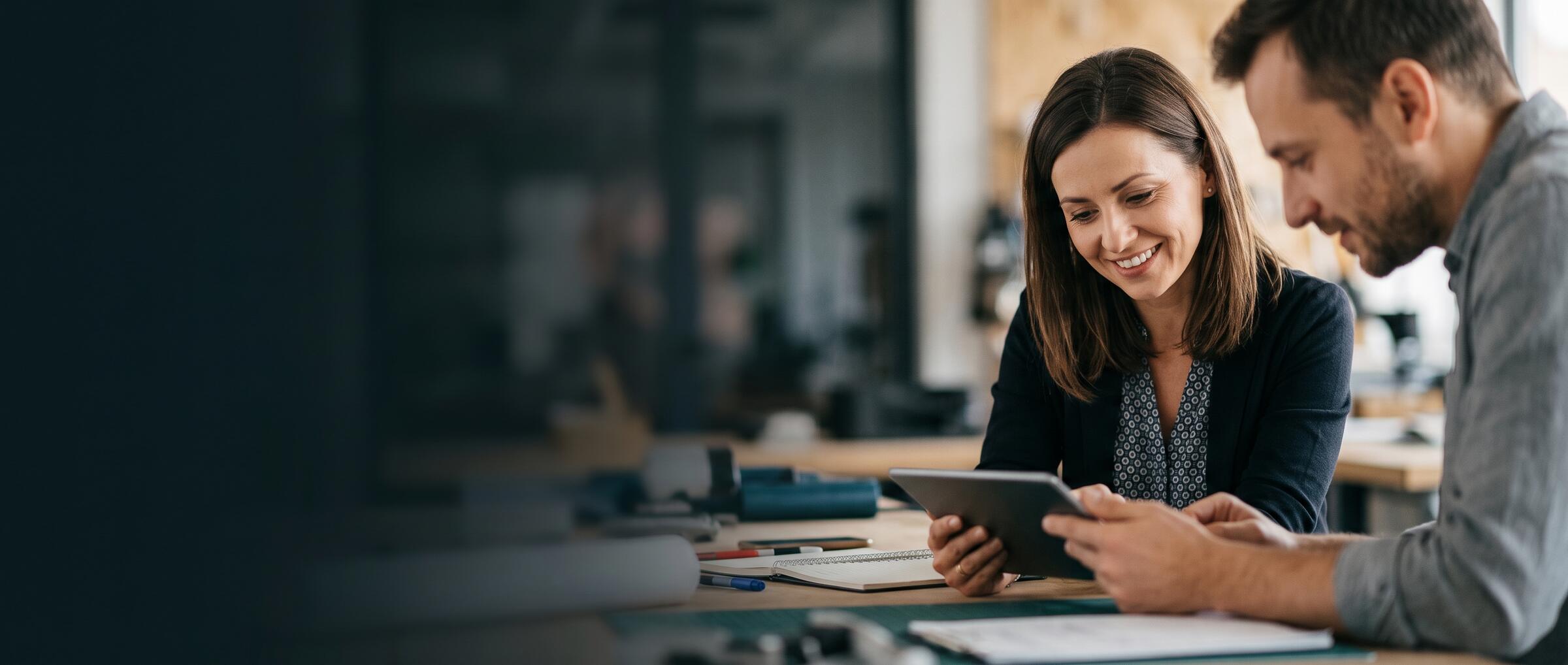 Pracownicy firmy omawiają plan szkolenia na tablecie